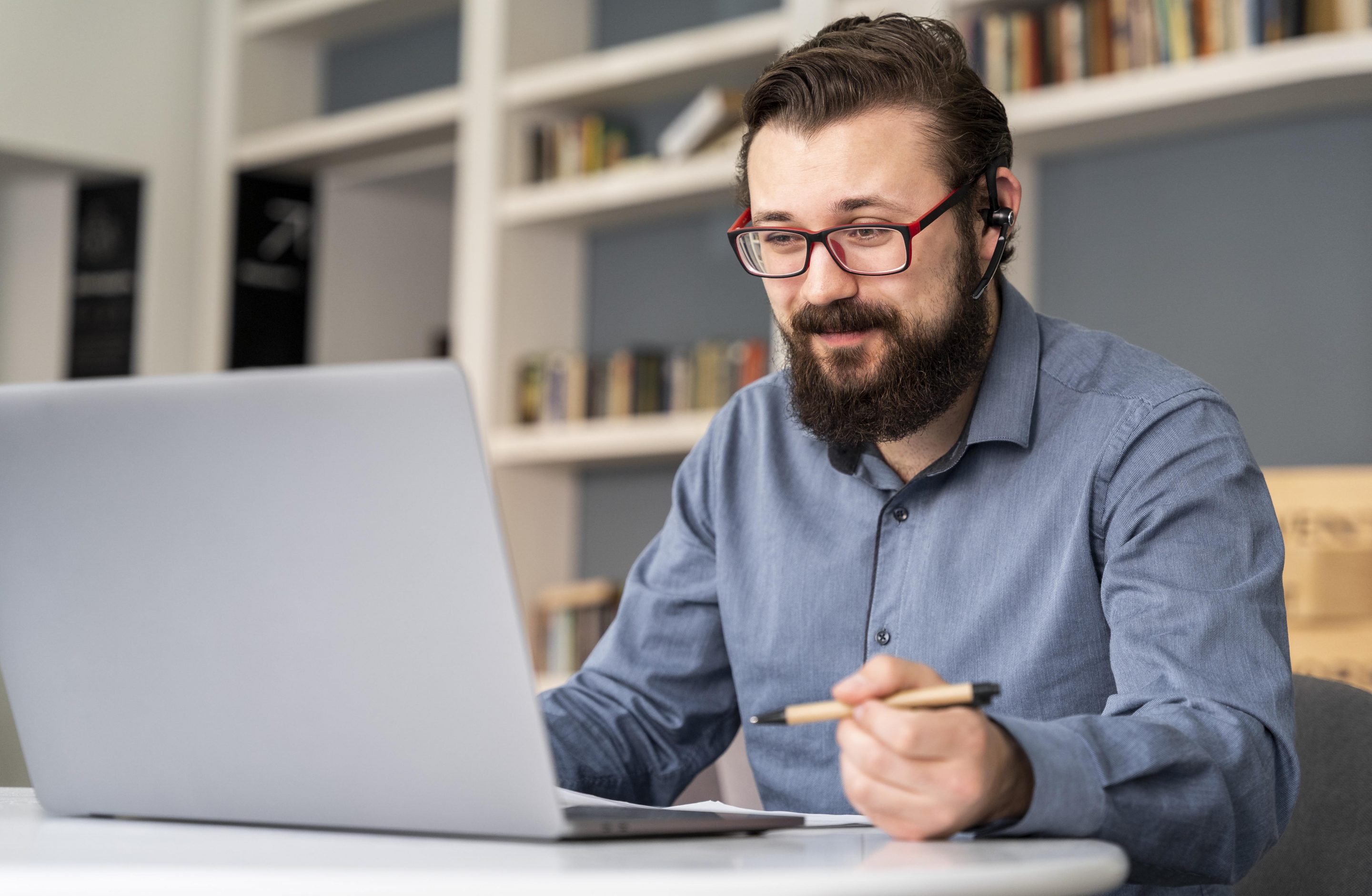 ventajas del e-learning, trabajador sentado en su mesa de trabajo en casa, con un ordenador portátil delante, estudiando