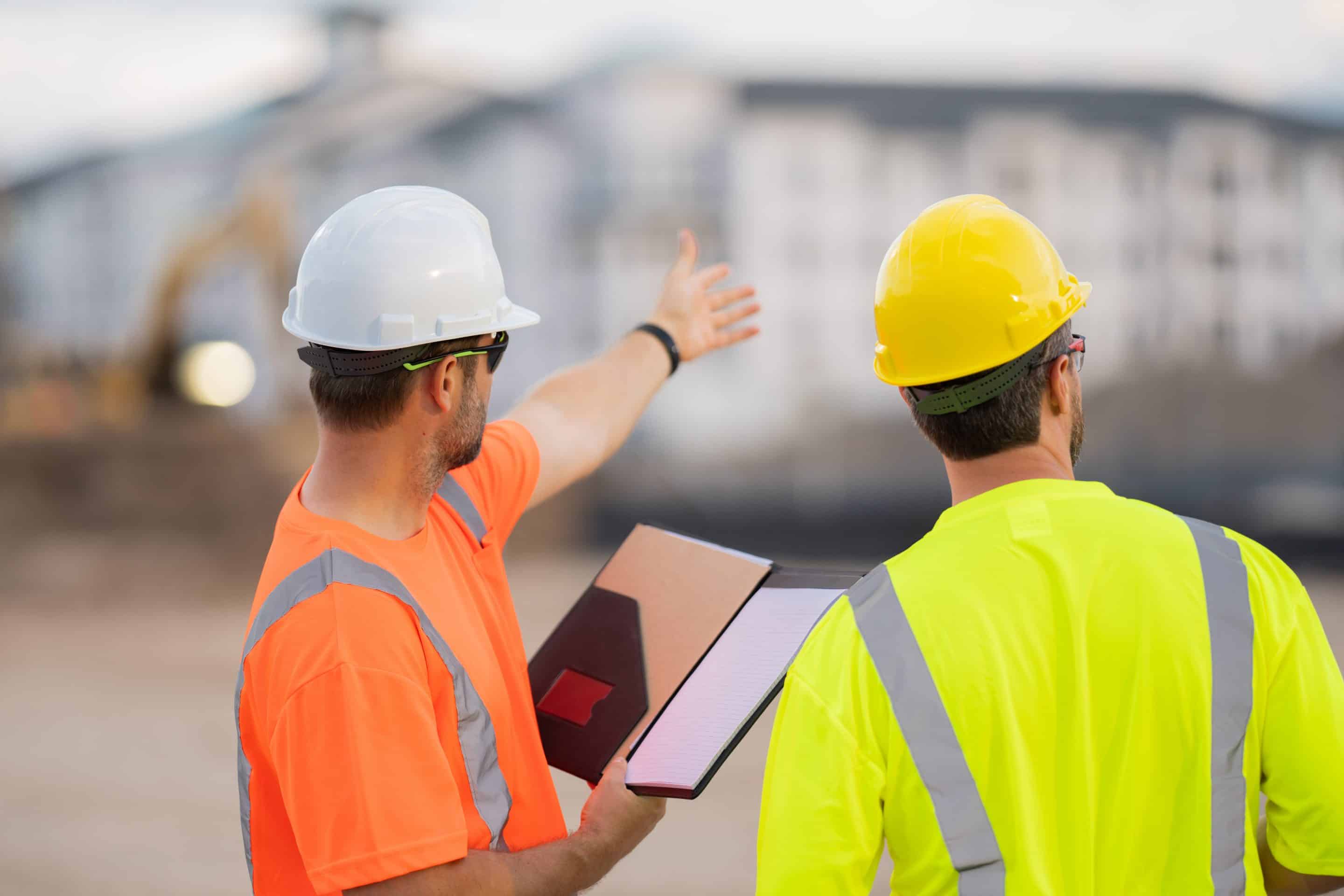 Un técnico de prevención de riesgos laborales indica a un trabajador un procedimiento seguro