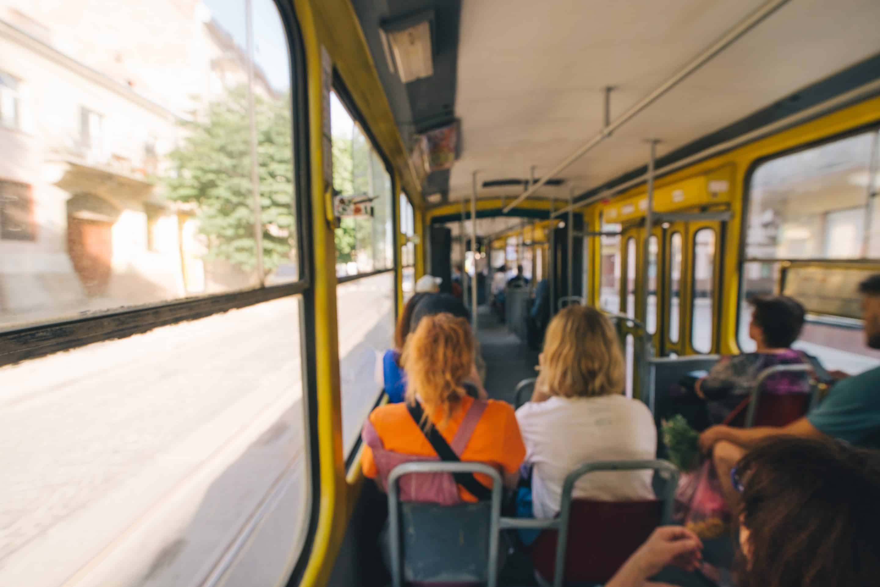 Personas sentadas dentro de un autobús en movimiento en un día soleado