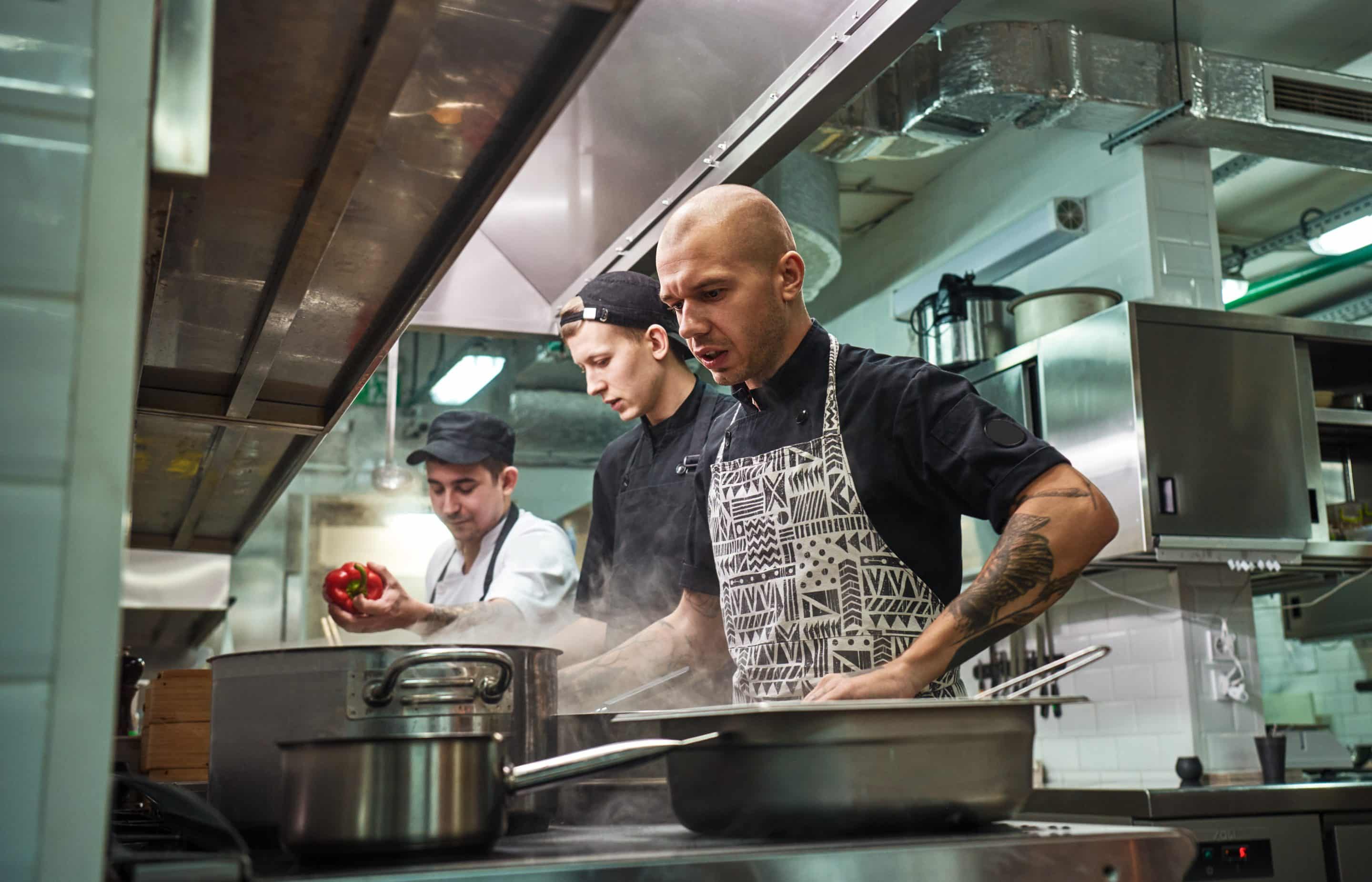 Tres cocineros trabajando en la cocina de un restaurante durante una ola de calor