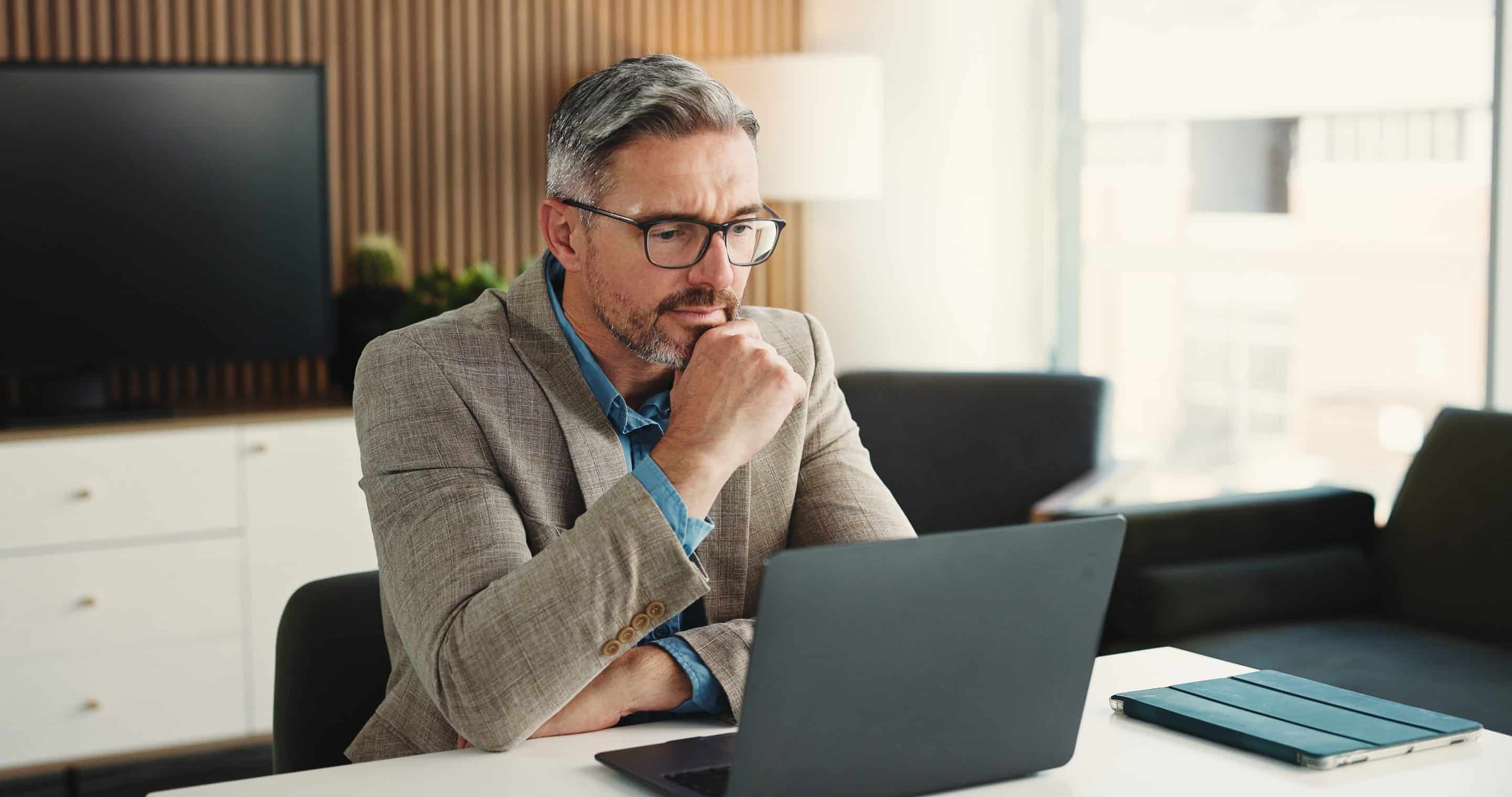 reading-online-man-with-laptop-office-decision-risk-assessment-website-research-financial-analyst-reflection-mature-person-with-tech-budget-review-wealth-management Una persona observa un portatil en actitud de revisar y tomar decisiones importantes, representando un uso responsable de la inteligencia artificial en la empresa