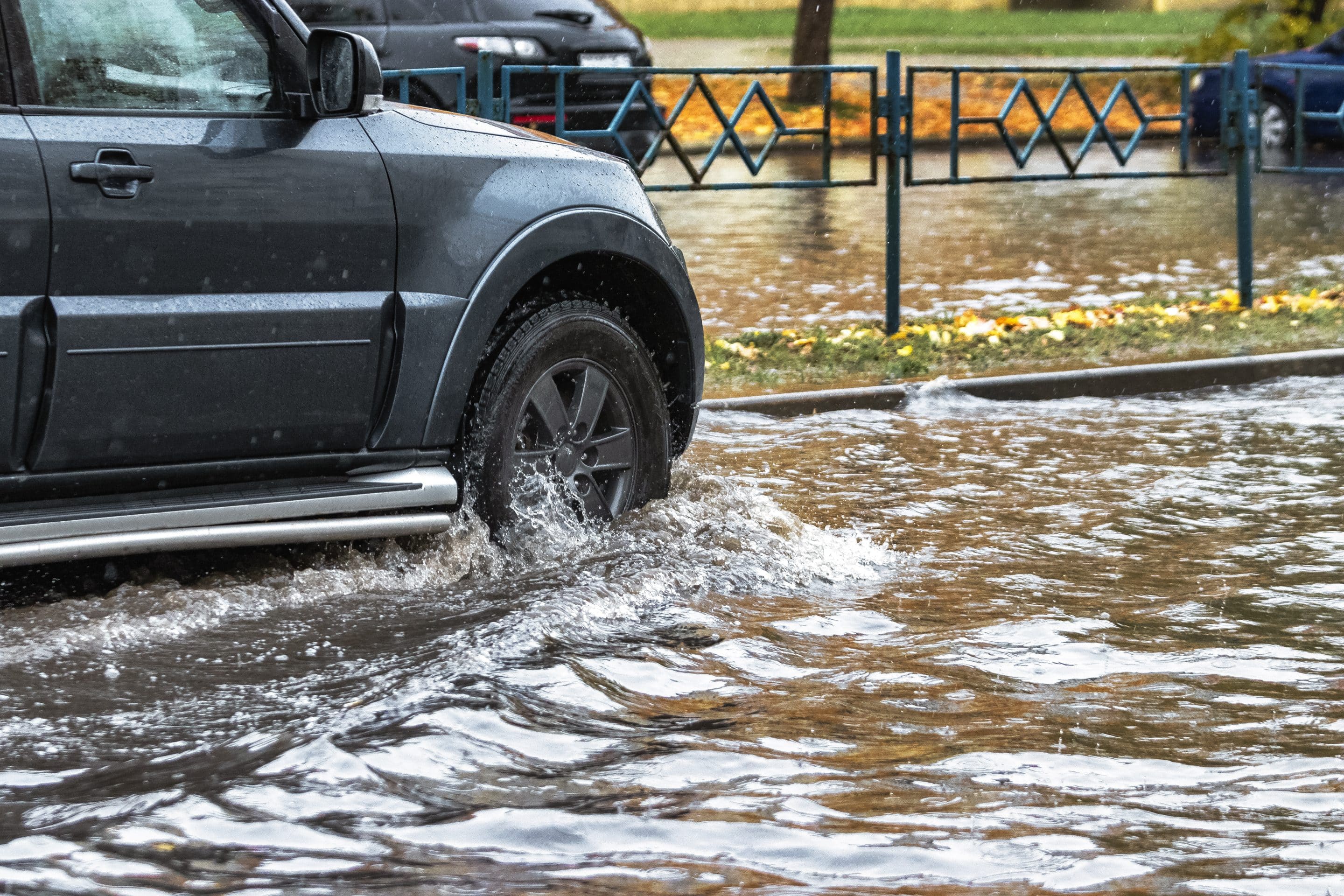 Vehículo circulando por una calle inundada tras lluvias intensas